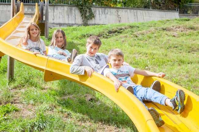 Kinder beim Spielen auf der Rutsche