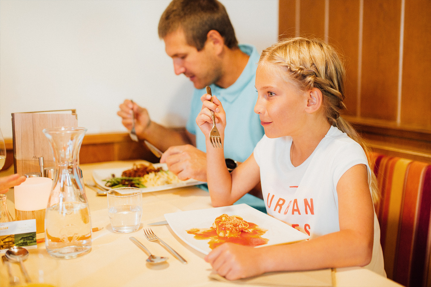Papa mit Kind beim Mittagessen im Familienhotel